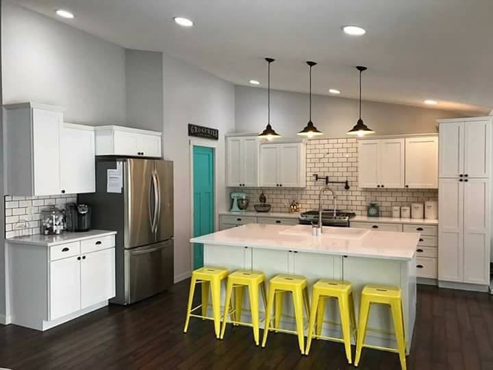 White kitchen with subway-tile backsplash and island with yellow stools